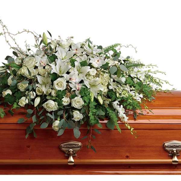 White floral spray on a wooden casket