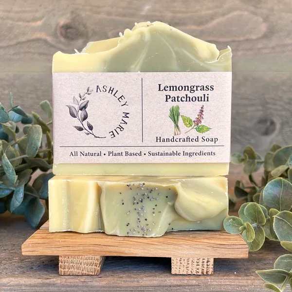 Two bars of lemongrass patchouli soap stacked on a small wooden stand