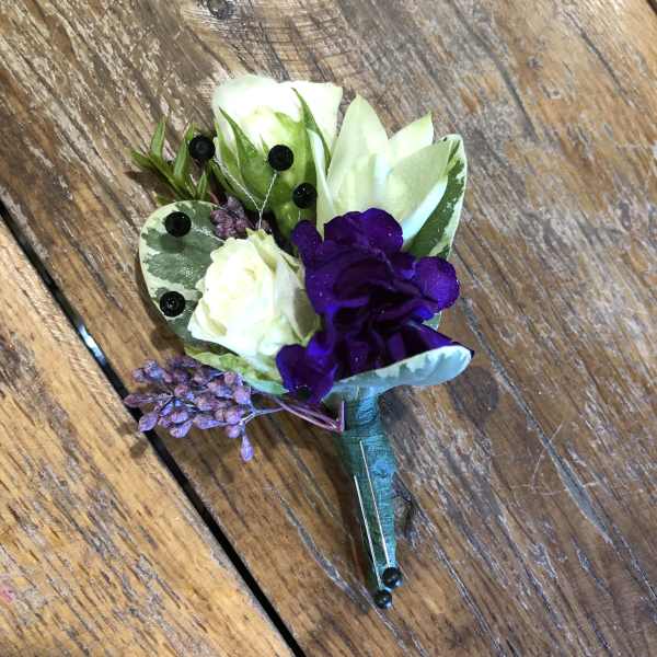 Small purple and white boutonniere with berries and leaves