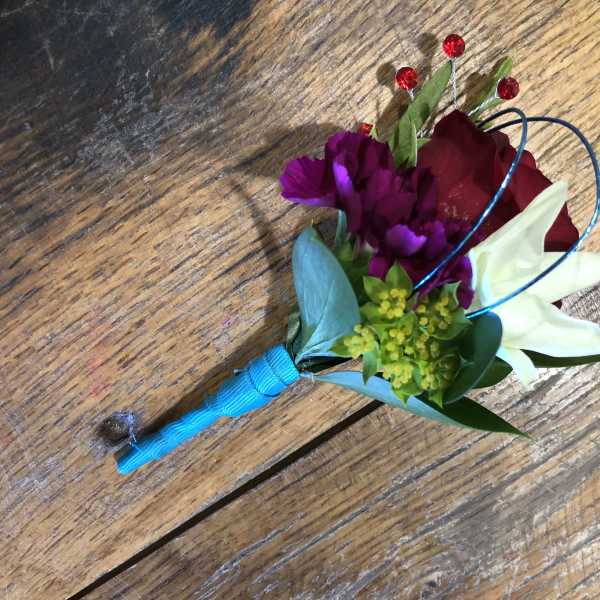 Small boutonniere with red, purple, and white flowers
