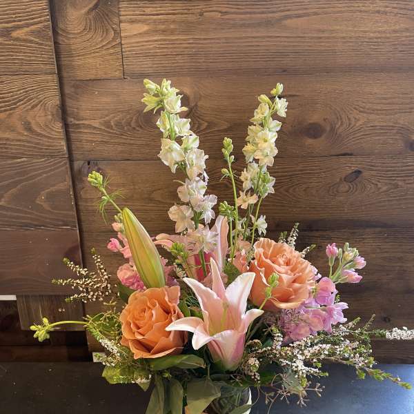 Pink and peach floral arrangement in a glass vase
