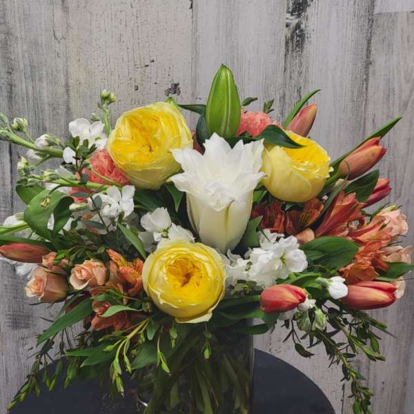 Mixed bouquet of yellow and white flowers in a glass vase