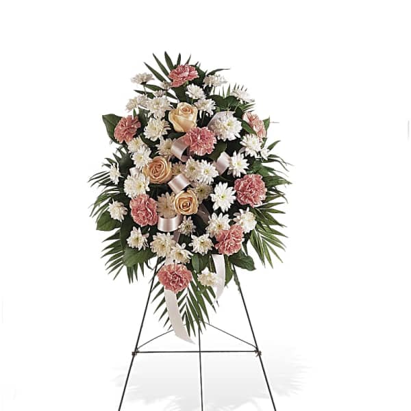 Standing floral wreath with pink and white flowers on an easel