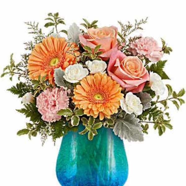 Mixed bouquet of pink roses, orange gerberas, and carnations in a blue vase