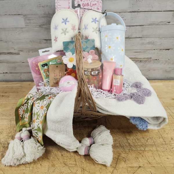 Gift basket with slippers, tumbler, bath items, and a scarf