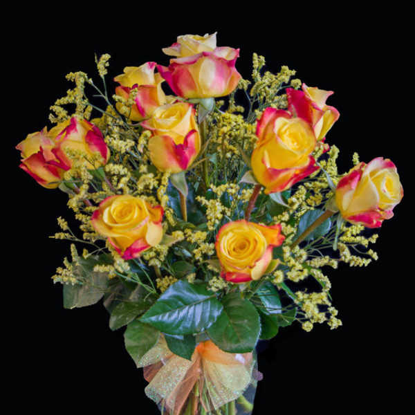Bouquet of yellow and pink roses in a clear glass vase