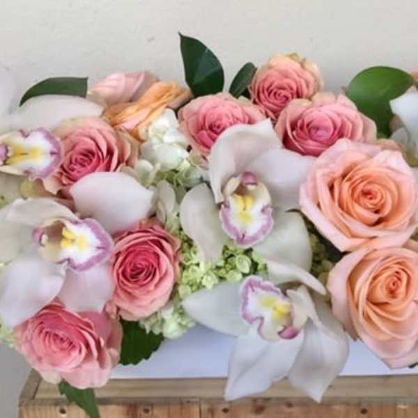 Pink and peach roses with white orchids in a white rectangular box