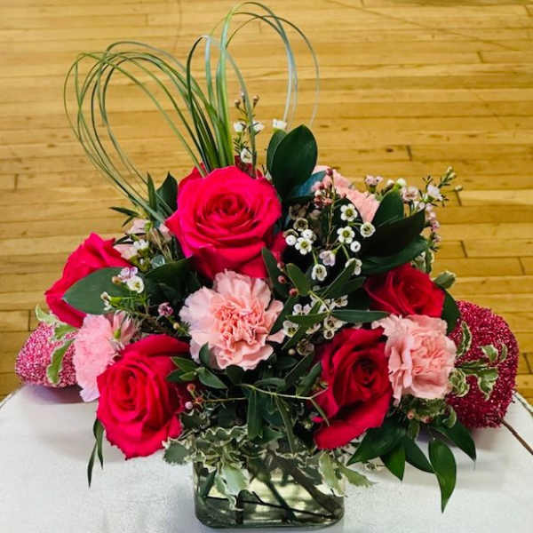 Bouquet of red roses and pink carnations in a glass vase