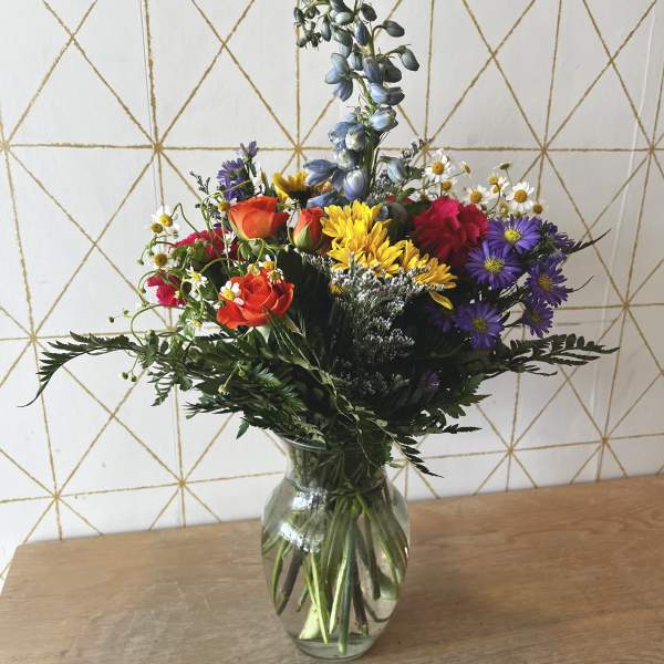 Mixed bouquet of colorful flowers in a clear glass vase