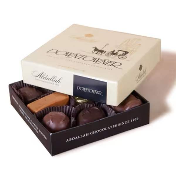 Open box of assorted chocolates with a lid on top