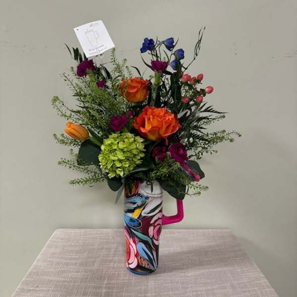 Colorful bouquet in a patterned mug-style vase