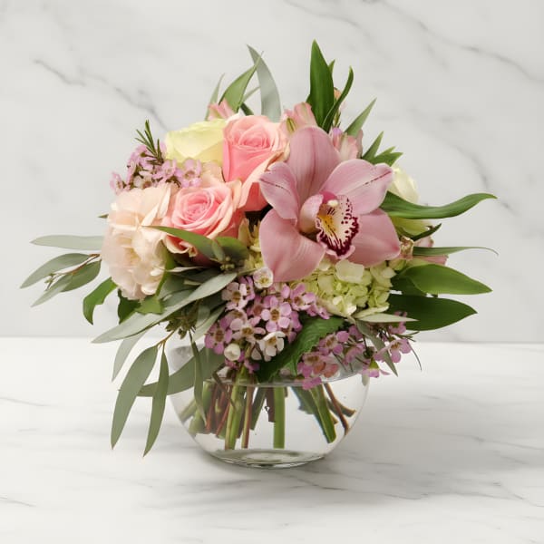 Pink and cream floral bouquet in a clear glass vase