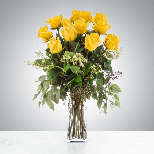 Yellow roses arranged in a clear glass vase