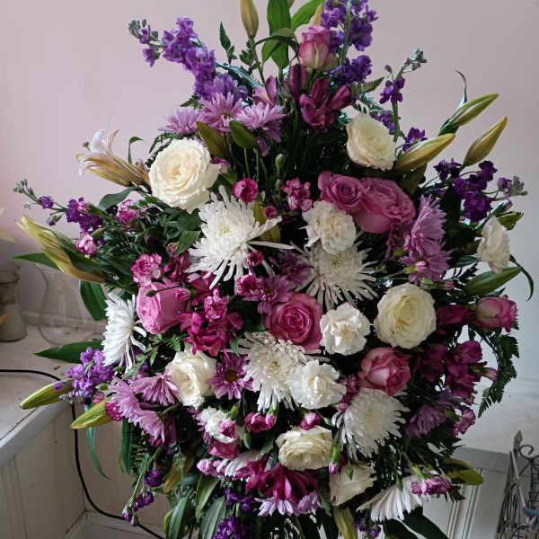Large standing floral spray with pink, white, and purple blooms