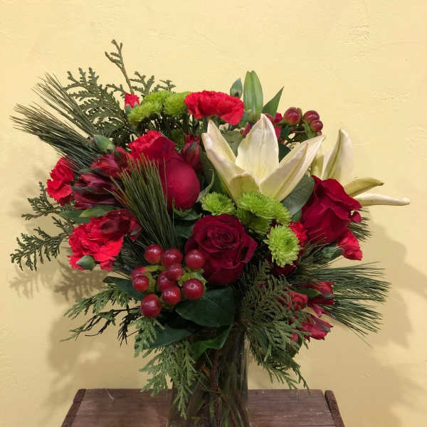 Red and white floral arrangement in a glass vase