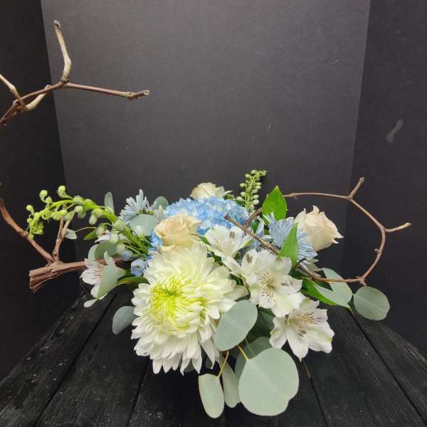 White and blue floral arrangement with branches and eucalyptus
