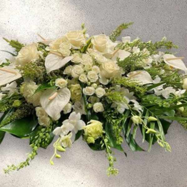 White floral casket spray with roses and orchids