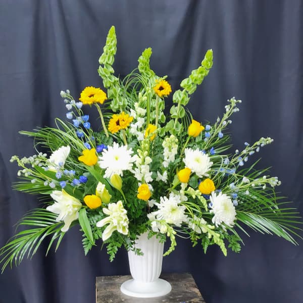 Large white vase arrangement with yellow and white flowers