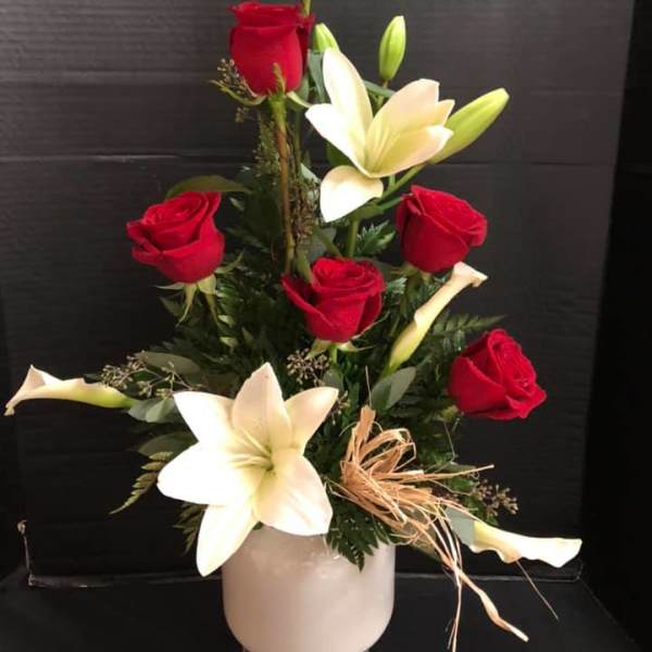 Red roses and white lilies arranged in a white vase