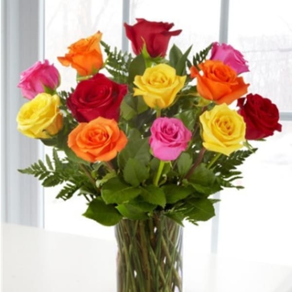 Colorful roses arranged in a clear glass vase