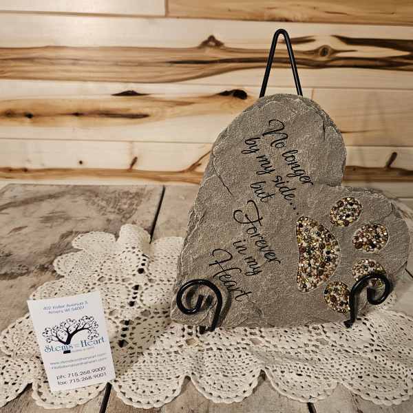 Heart-shaped memorial stone on a stand with paw prints and script text
