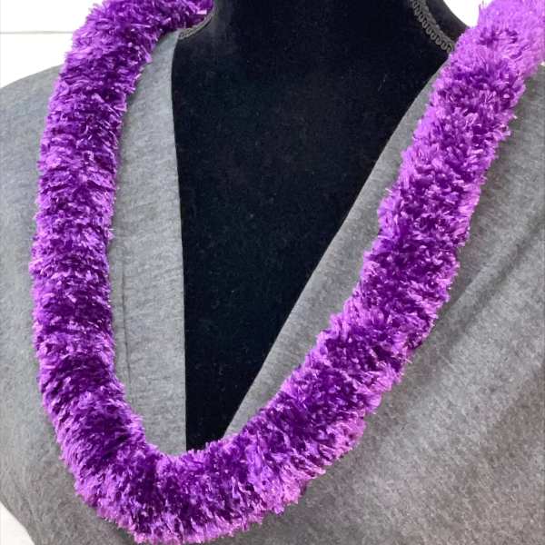 Plush purple lei necklace displayed on a black mannequin torso