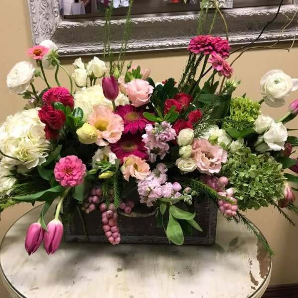 Mixed pink, white, and green floral arrangement in a rectangular container