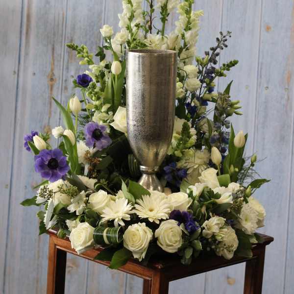White and purple floral arrangement in a silver vase