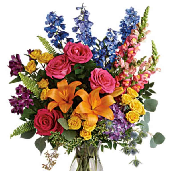 Colorful bouquet of roses, lilies, and snapdragons in a glass vase