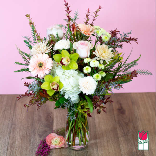Mixed bouquet in a clear glass vase with pink, white, and green flowers