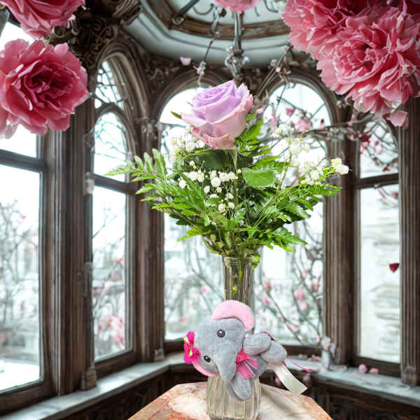 Pink rose in a glass vase with a small plush elephant