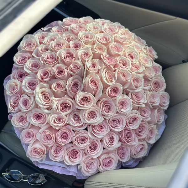 Large round bouquet of pale pink roses on a car seat