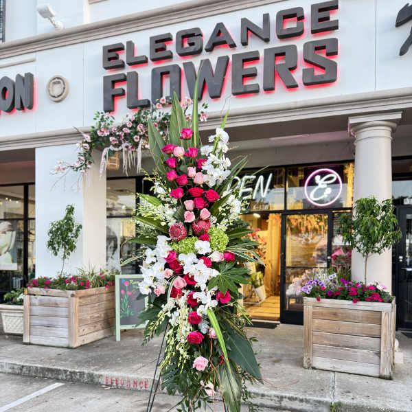 Tall standing floral spray with pink and white flowers on a metal easel