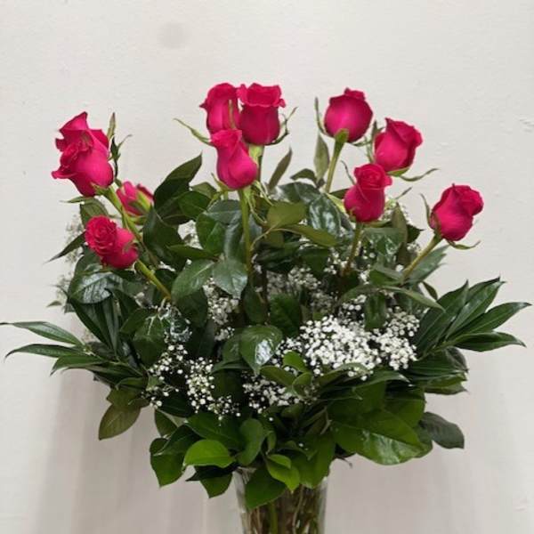 Tall vase arrangement of hot pink roses with baby's breath