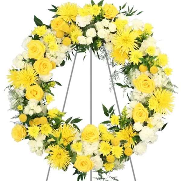 Yellow and white floral wreath on a metal stand