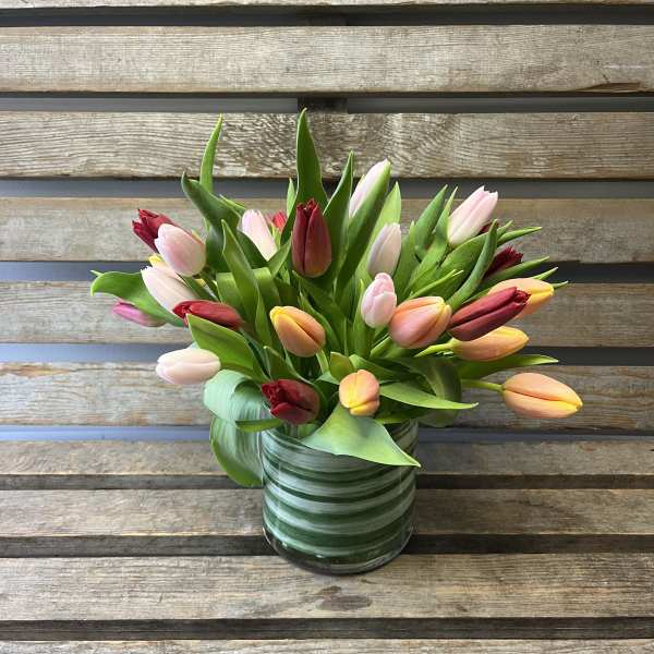 Mixed tulips in a striped glass vase