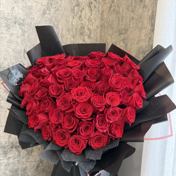Large bouquet of red roses wrapped in black paper