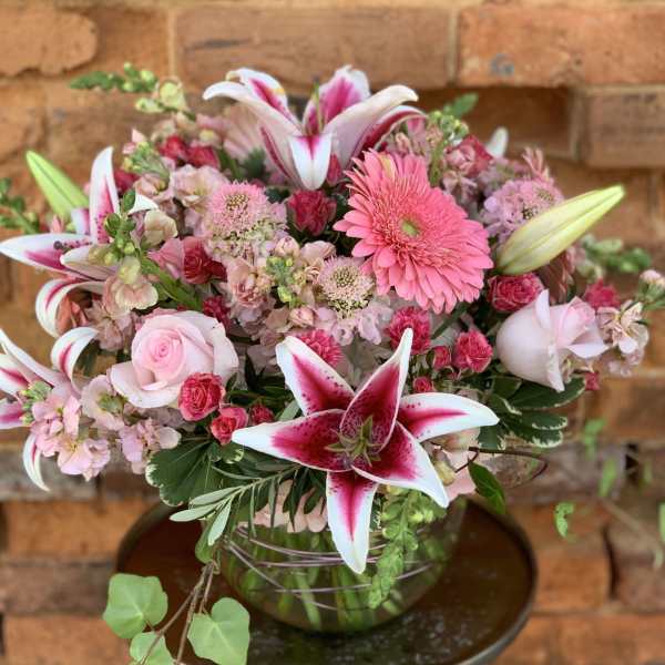Pink and white mixed flower arrangement in a glass vase