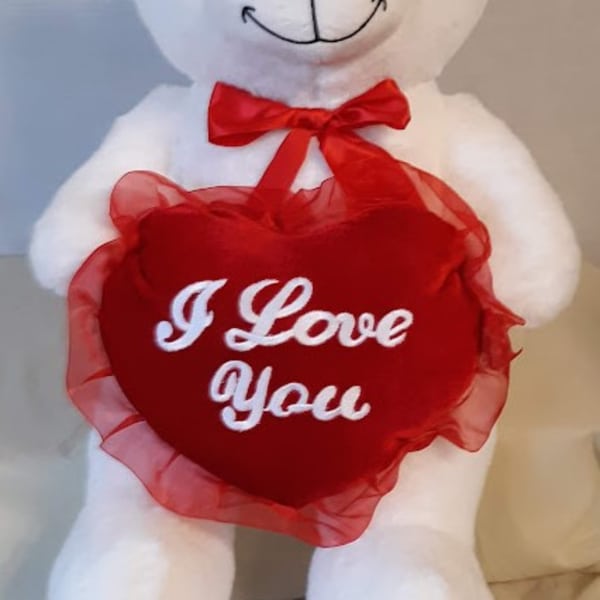 White teddy bear holding a red heart with "I Love You" text