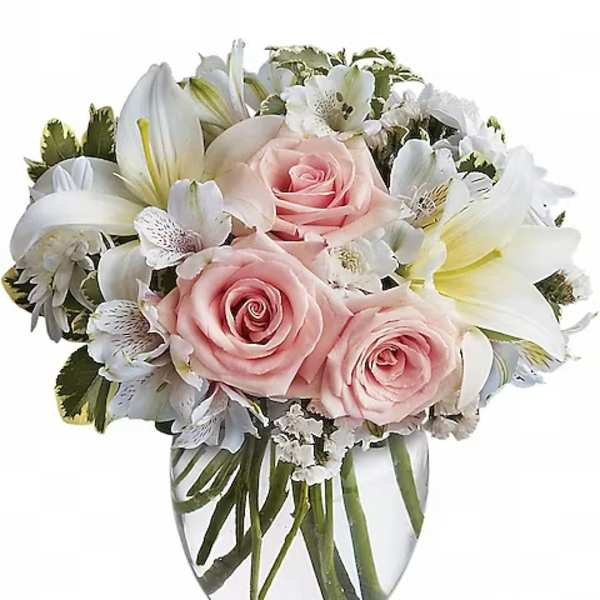Pink roses and white lilies arranged in a clear glass vase