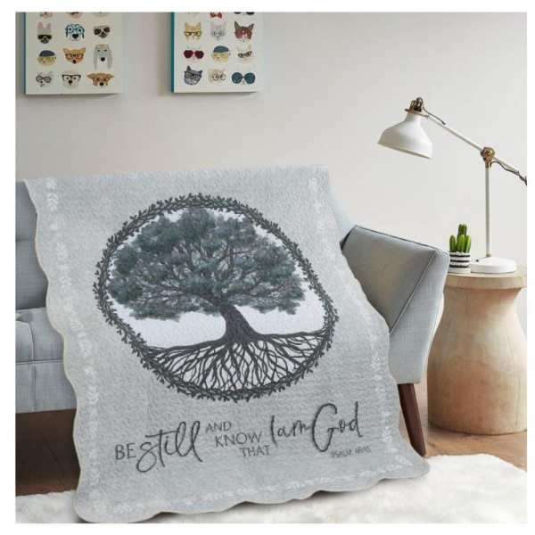 Tree-themed quilt draped over a sofa in a living room