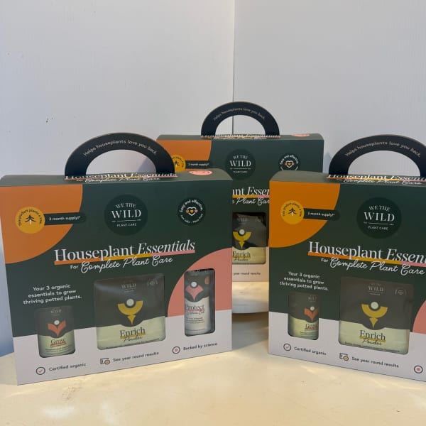Three houseplant care kits in dark green and orange boxes.