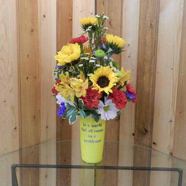 Mixed bouquet with sunflowers and carnations in a yellow vase
