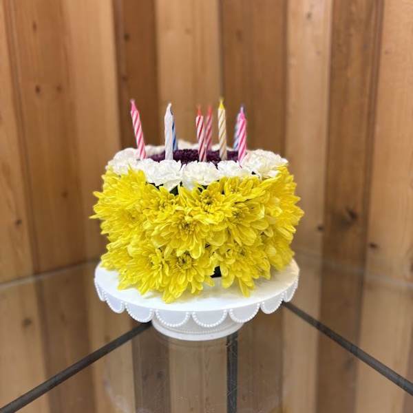 Yellow and white flower cake with striped candles on top
