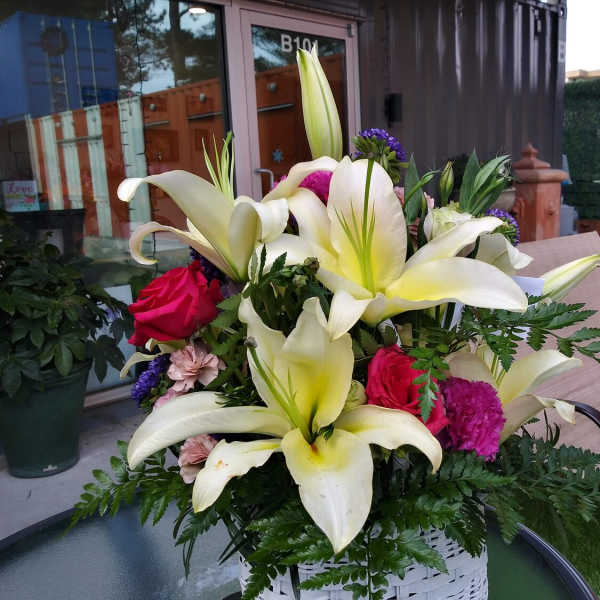 Bouquet of white lilies and pink roses in a white basket