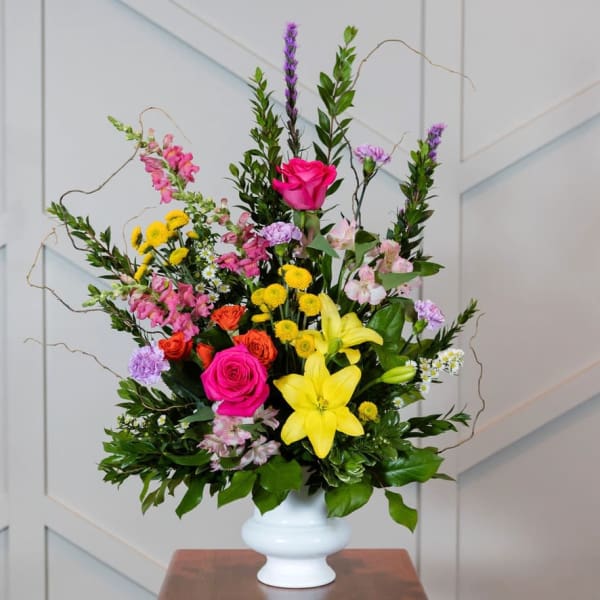 Mixed bouquet with pink roses and yellow lilies in a white vase