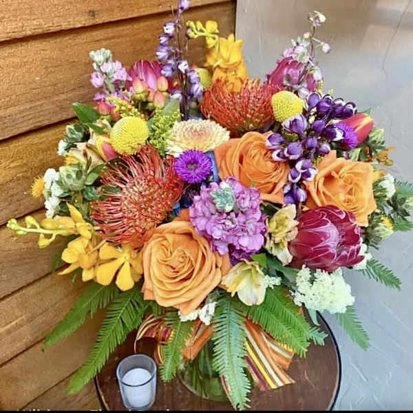 Colorful mixed bouquet with roses, protea, and orchids