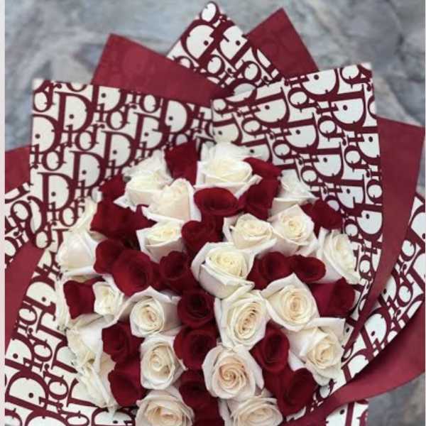 Bouquet of red and white roses wrapped in patterned paper