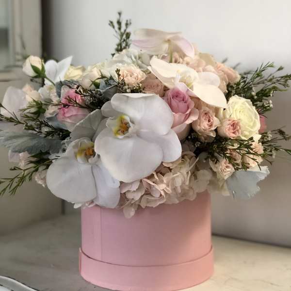 Pink hatbox arrangement with white orchids and pale roses