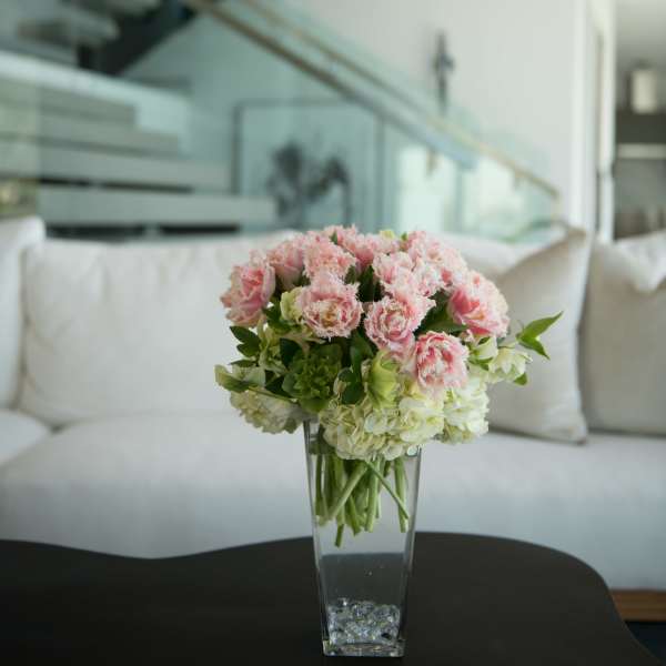 Pink and white flowers arranged in a clear glass vase